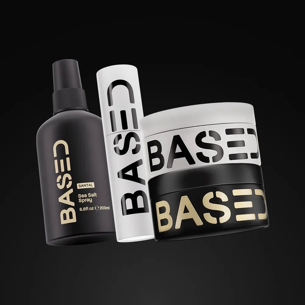 Three BASE hair styling products including a dark spray bottle, white dry shampoo can, and black and white styling product box on black background